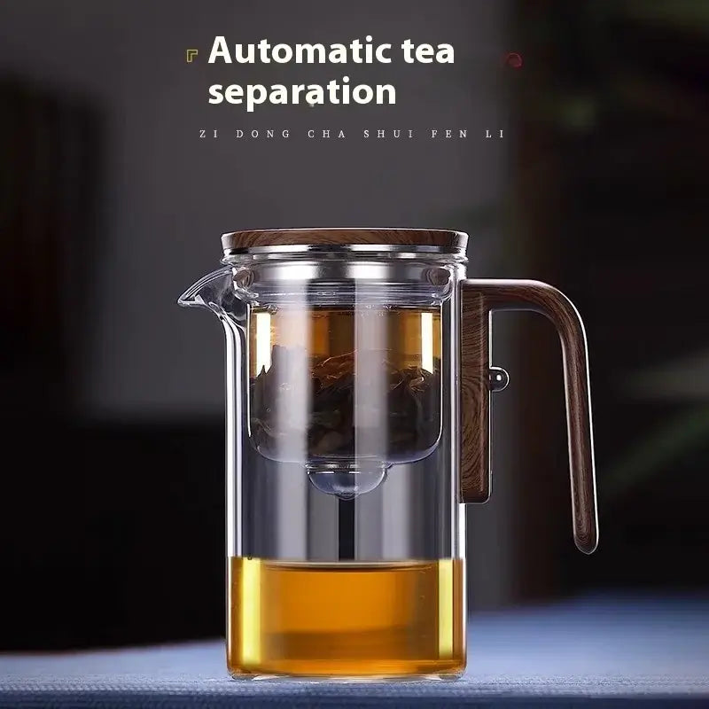 Elegant glass teapot with automatic tea separation and wooden handle, showcasing brewed tea and loose leaves.